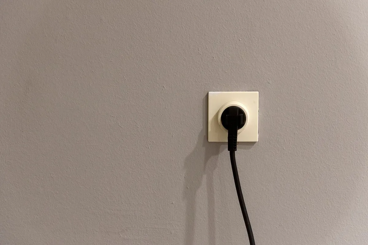 White Australian wall socket outlet with AS/NZS 3112 flat pin apertures photographed against a plain wall