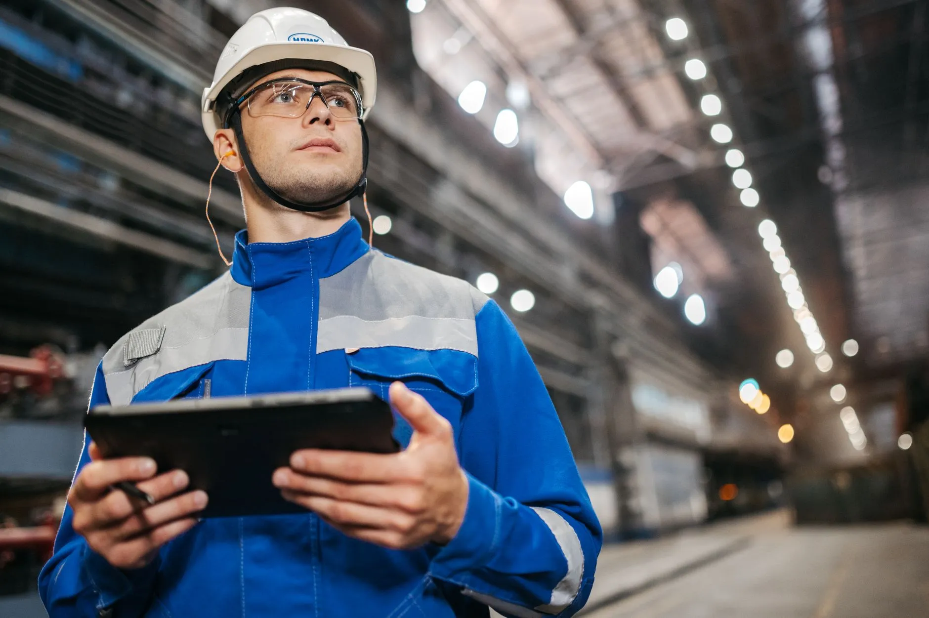Buyer taking notes during an on-site audit of production equipment at an LED lighting manufacturer