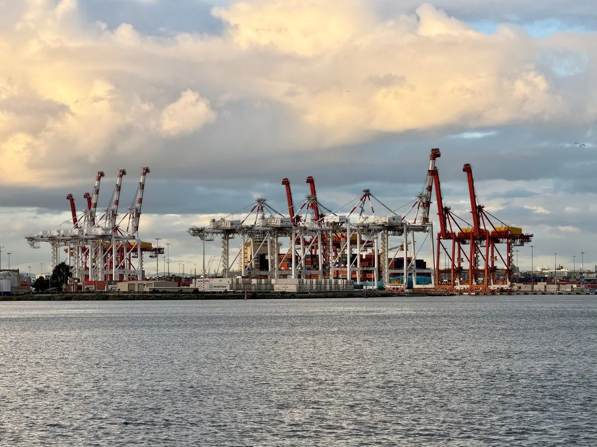 Container cranes at an Australian port at sunset, the arrival point for imported SAA and RCM compliant lighting accessories
