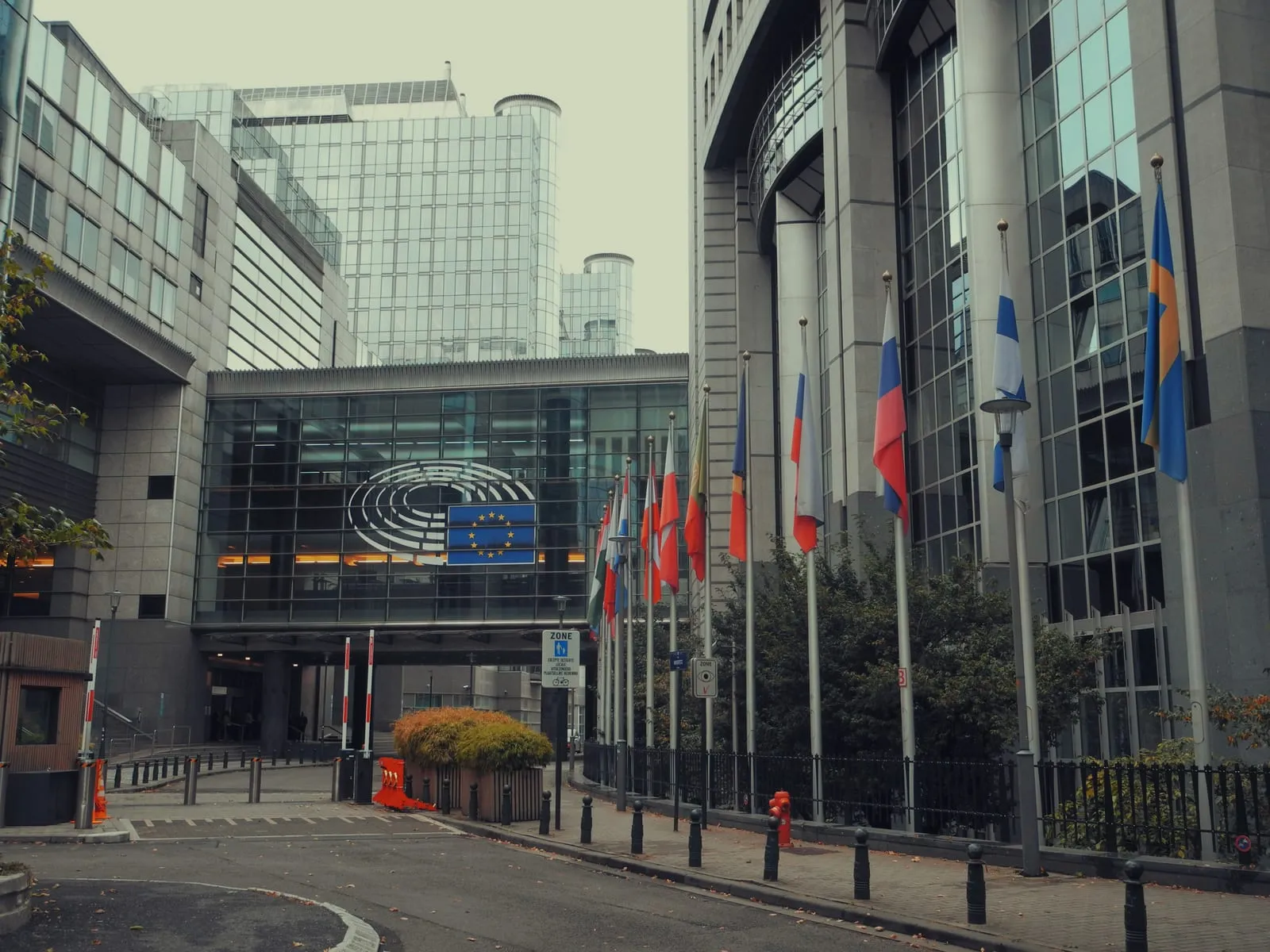 CE vs ENEC for LED lighting — the European Parliament building in Brussels with EU member flags, the regulatory backdrop for CE marking and ENEC certification