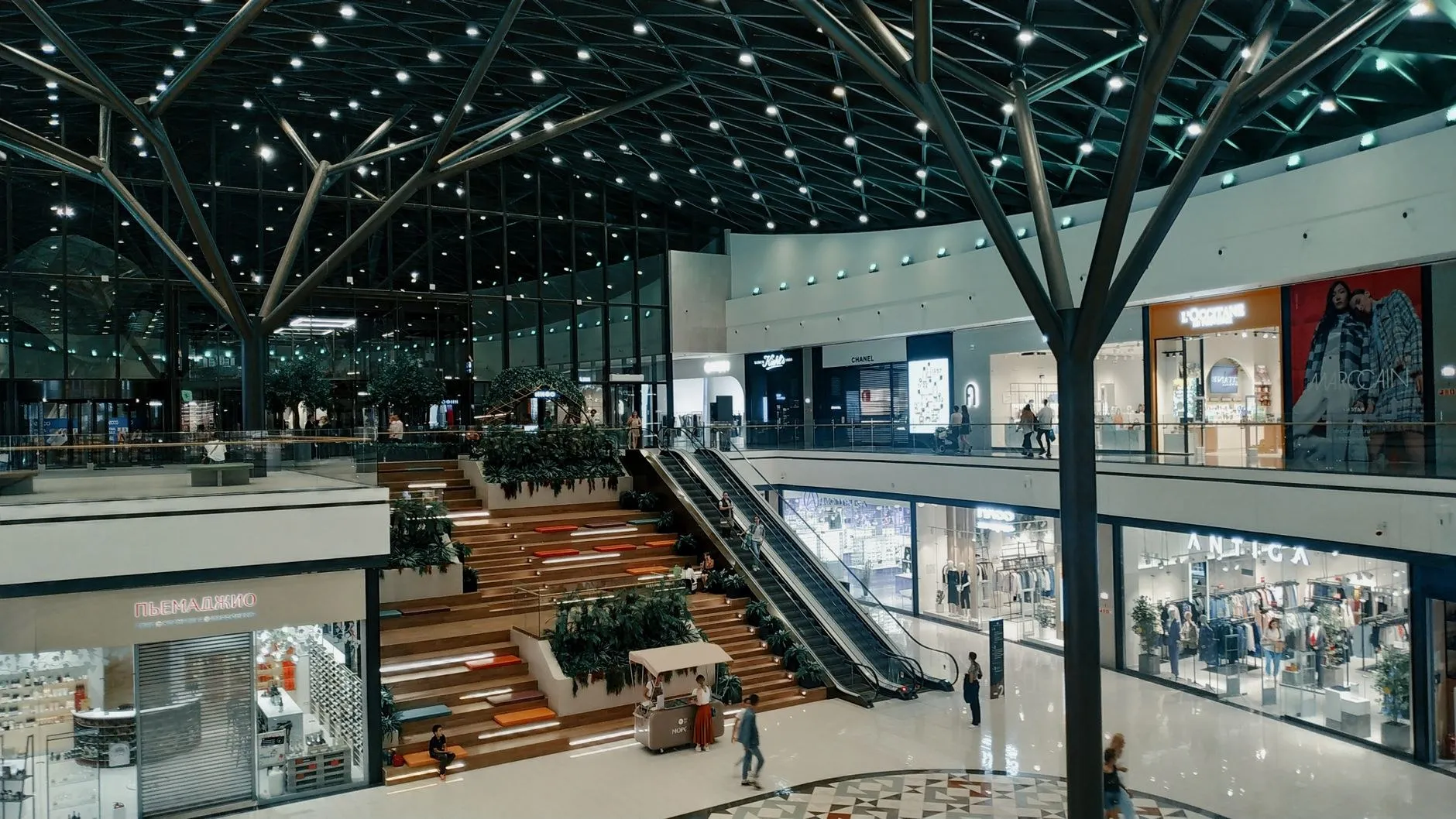Ceiling of a modern shopping mall covered in thousands of commercial recessed downlights on a structural grid, a typical commercial lighting project scale