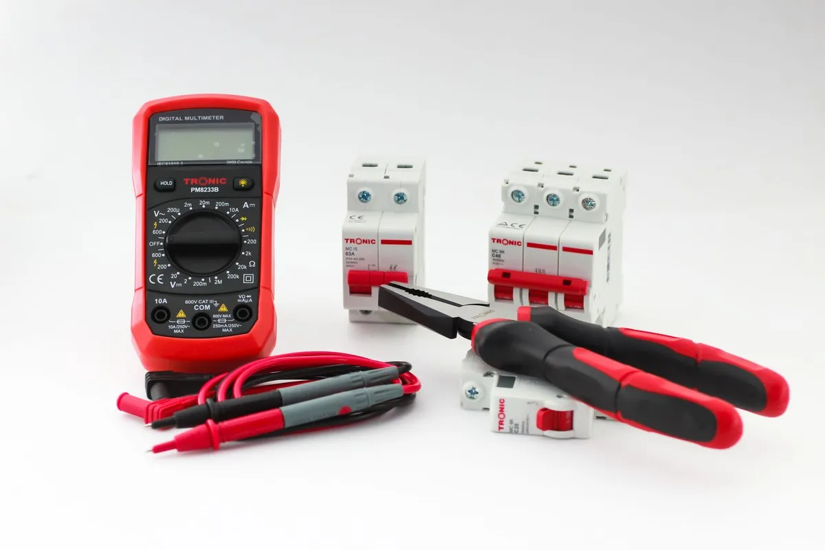 Digital multimeter and electrical test tools on a bench used for type testing accessories to Australian electrical safety standards