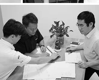 ENCORE engineers reviewing a downlight sample and technical drawings at a meeting table, the sampling stage of an ODM downlight project