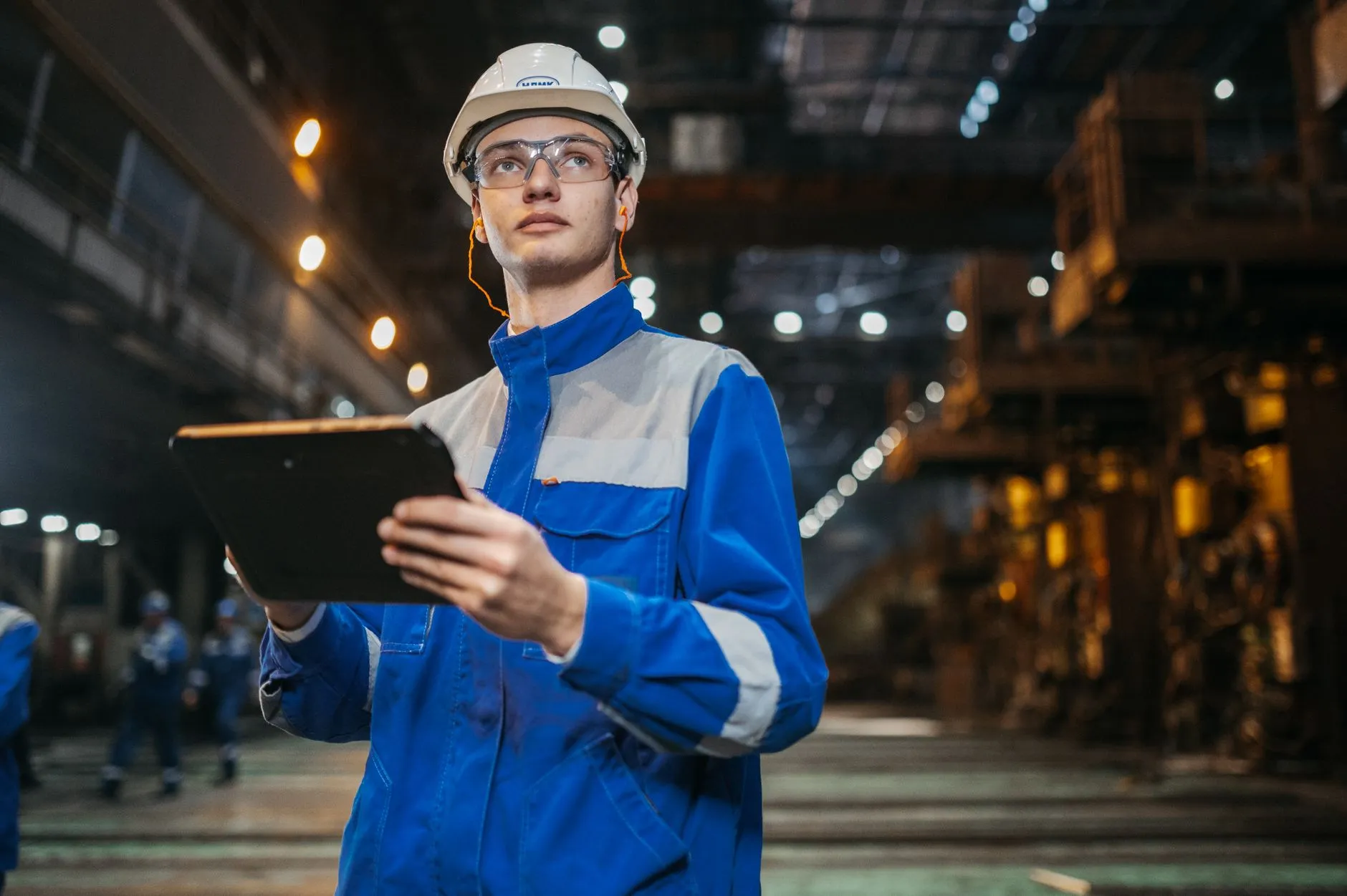 Engineer reviewing a lighting manufacturing process on a tablet inside the plant