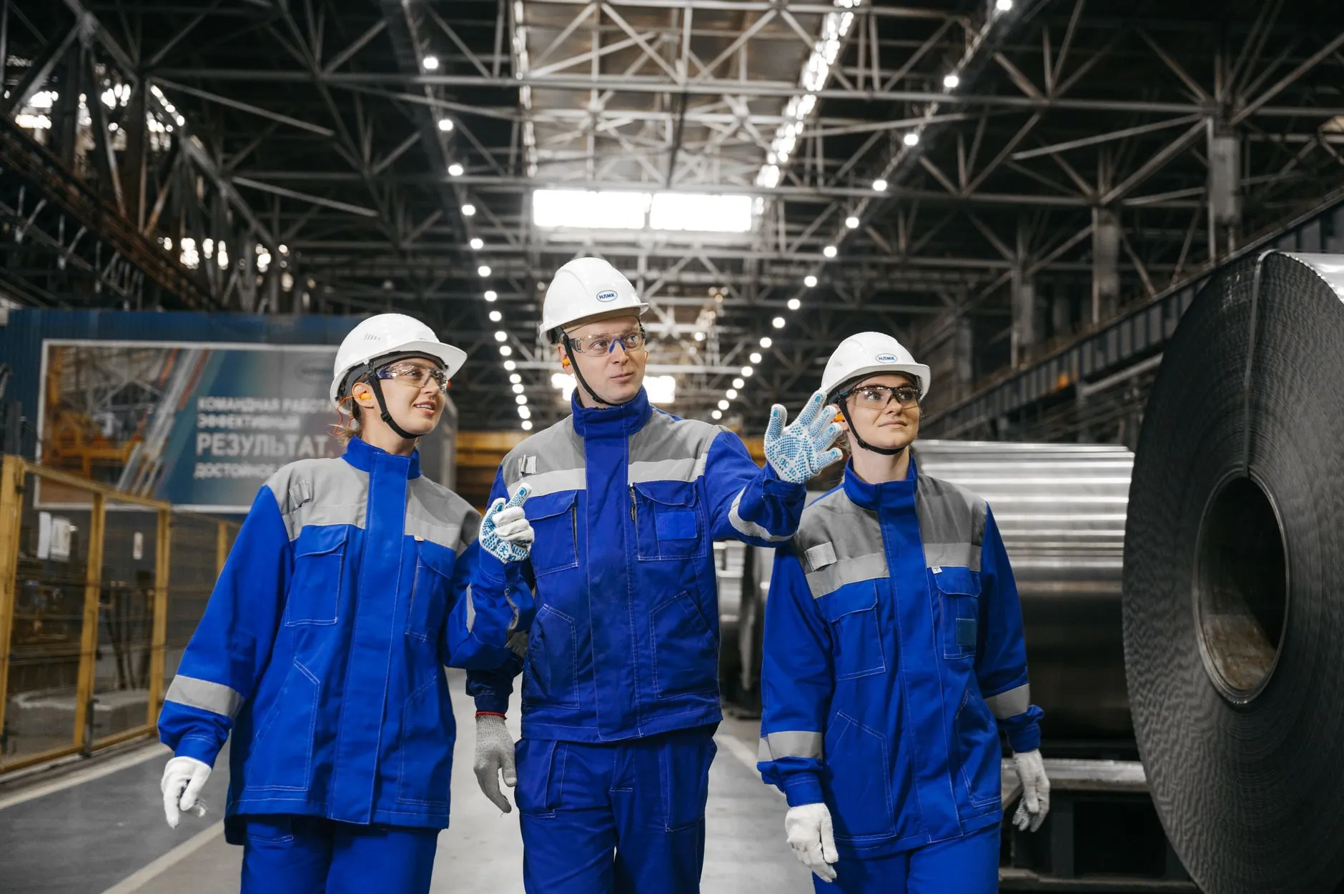 Buyer in a hard hat holding supplier paperwork during an audit of an LED lighting manufacturer