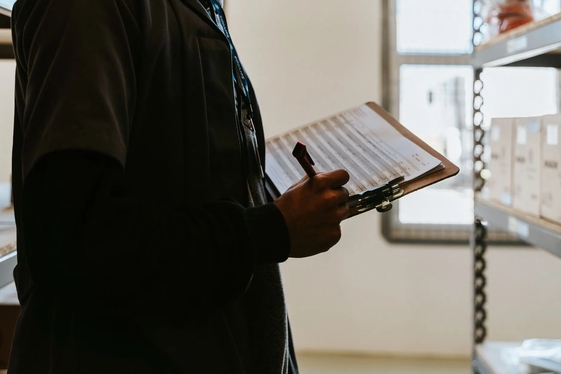 Inventory count with a clipboard in the racking of a lighting component warehouse