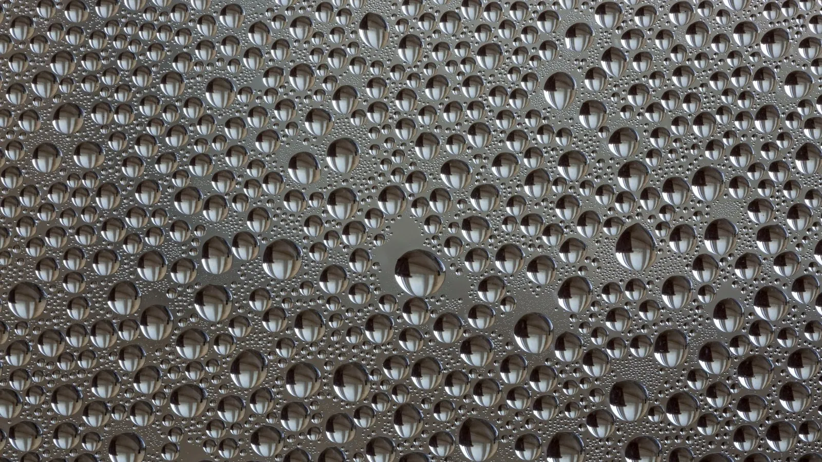 Water beading on the powder-coated metal surface of an IP65 weatherproof LED luminaire housing