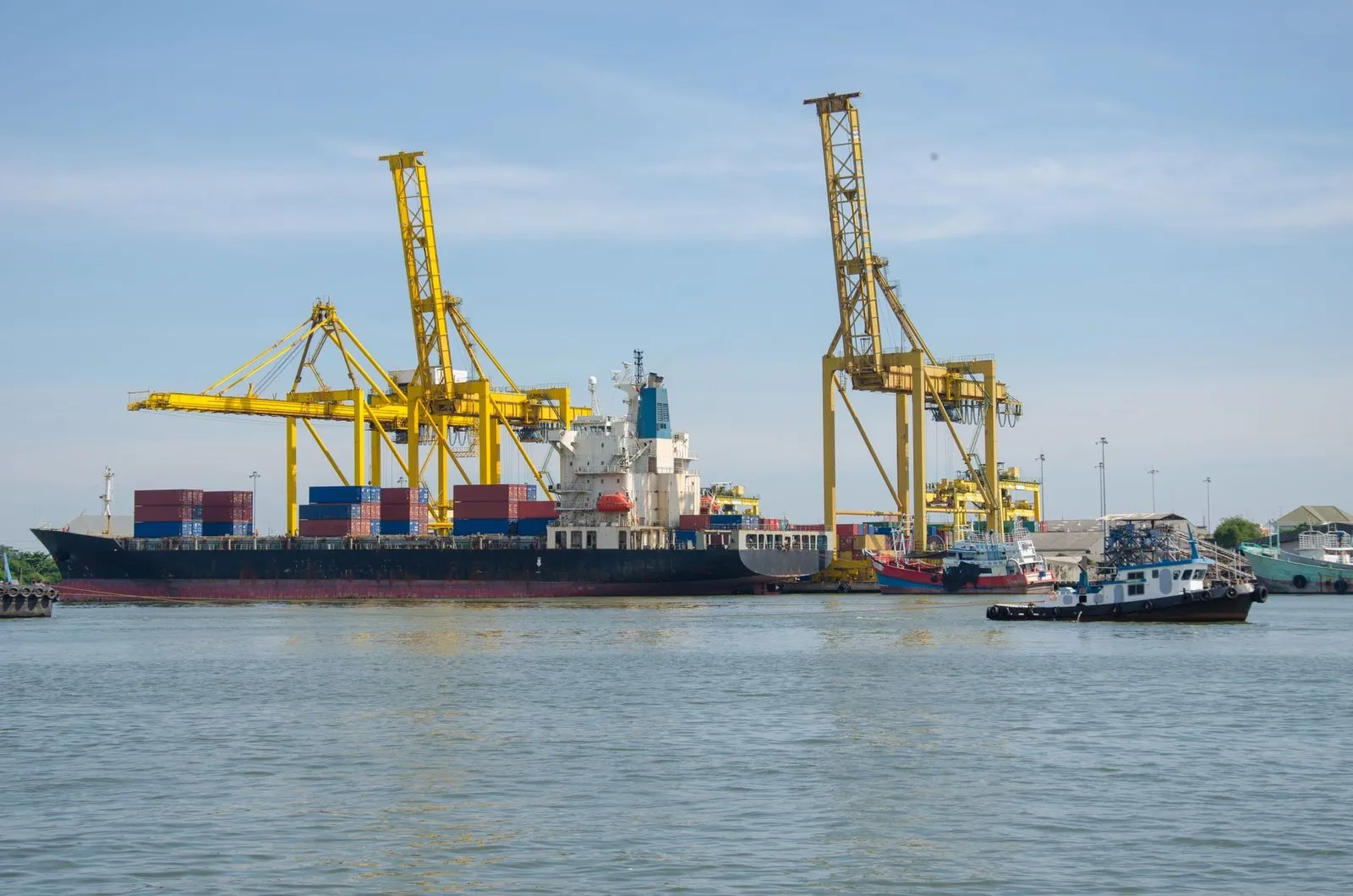 Container ship and gantry cranes loading export containers at a port terminal, the freight stage of a custom LED track lighting order shipped from China