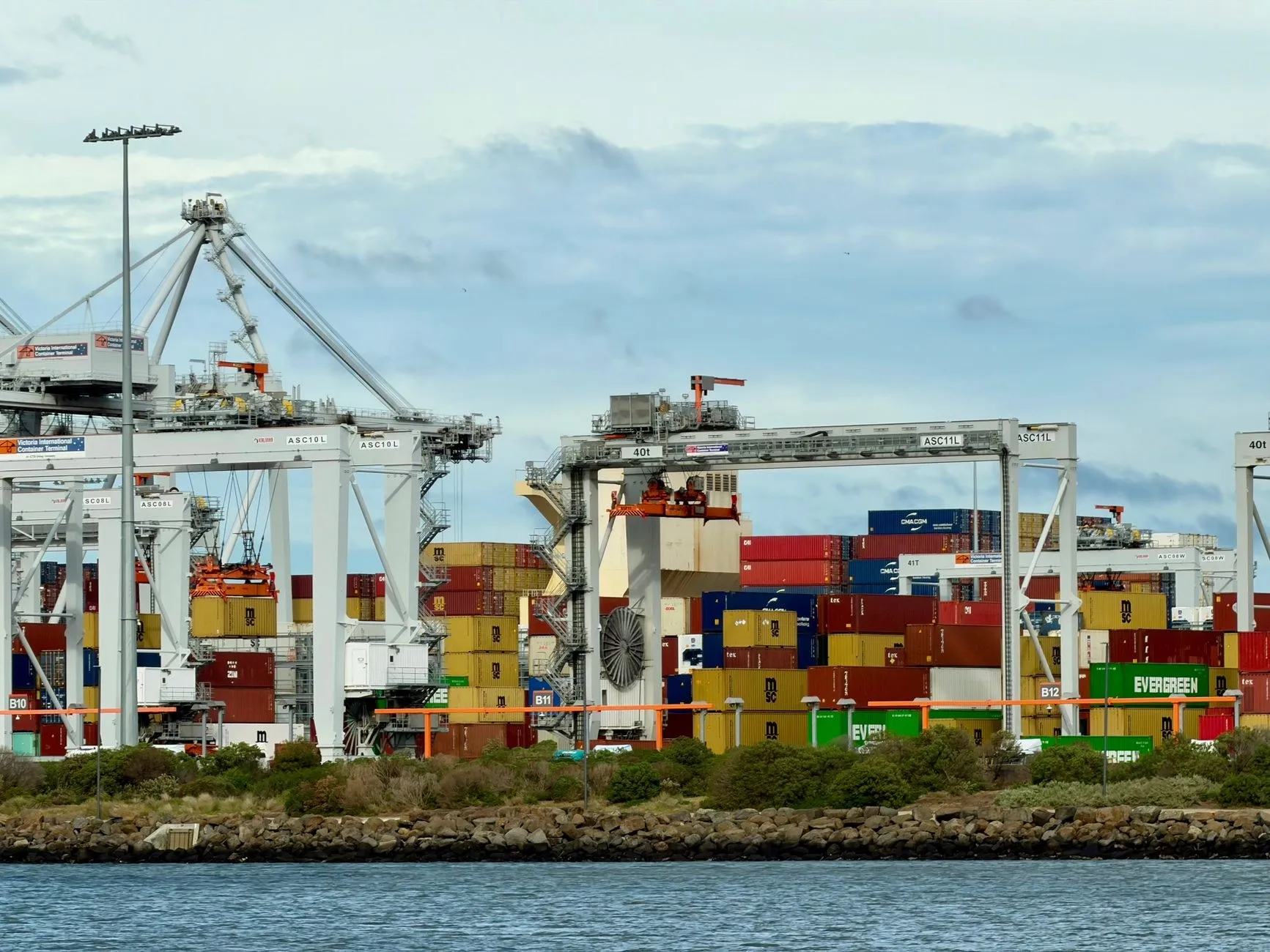 Container terminal at Port Melbourne with stacked shipping containers and cranes, the arrival point for SAA certified lighting imports into Australia