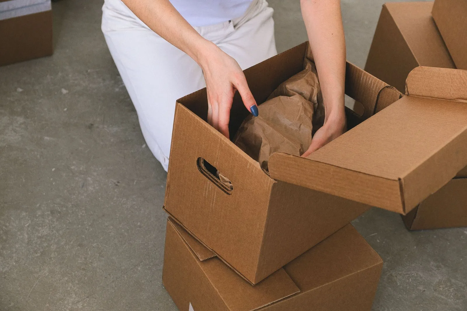 Cardboard cartons being packed on a workbench, illustrating the batch sizes behind a private label lighting MOQ