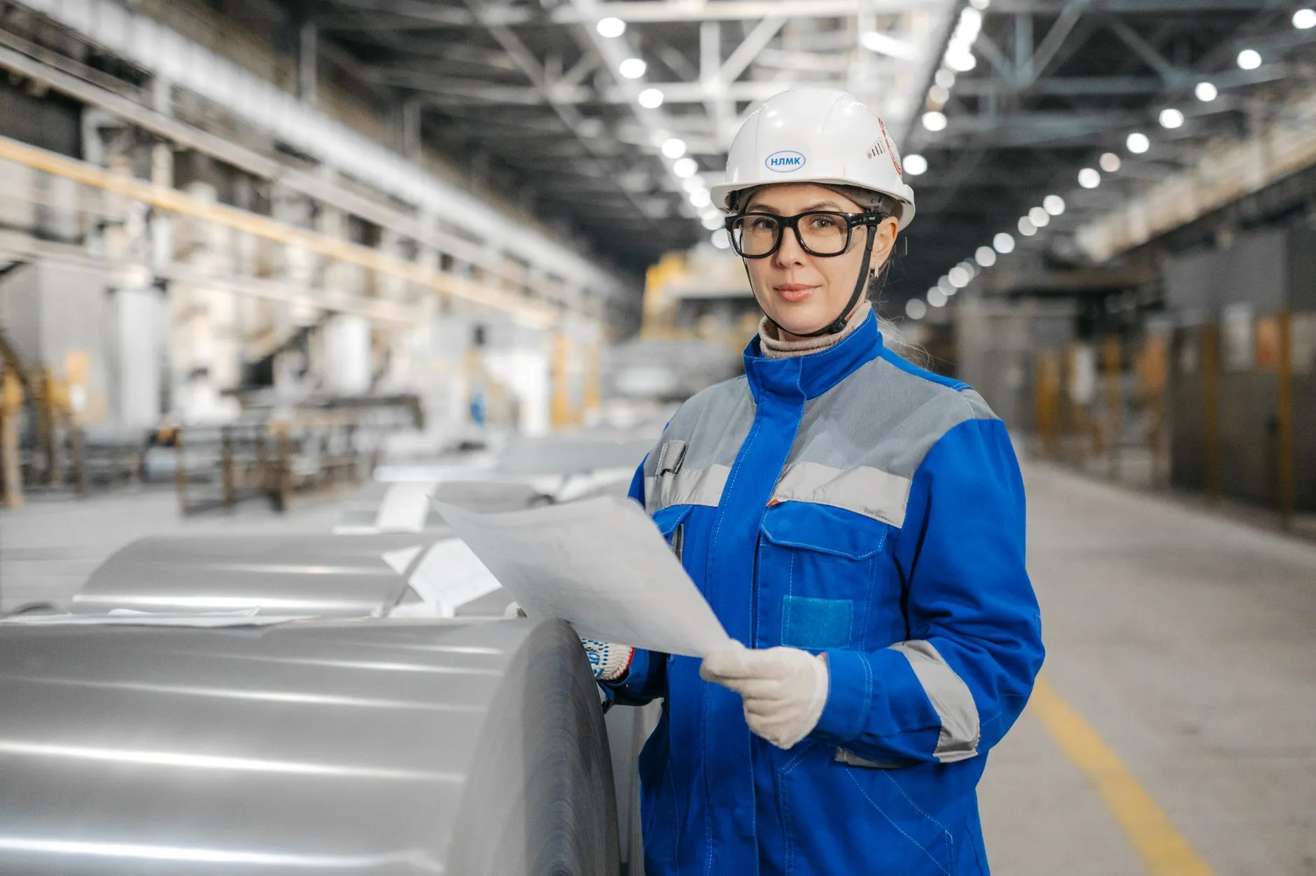 Quality engineer reviewing production documents on the factory floor of an LED lighting manufacturer