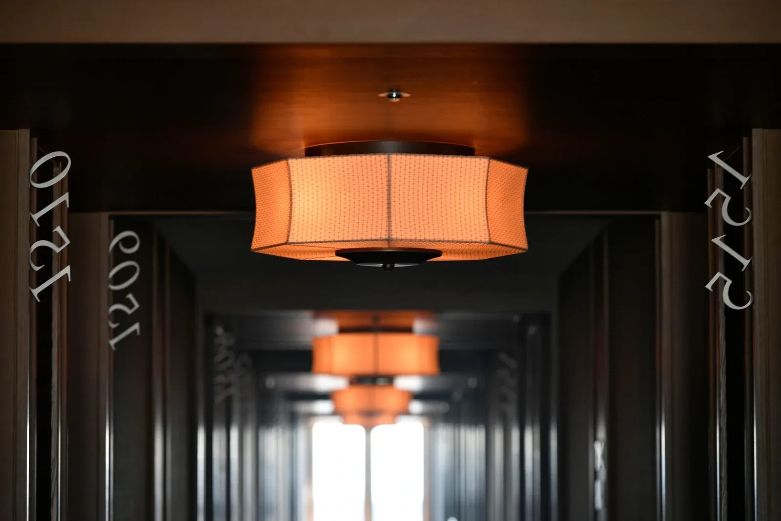 Hotel corridor ceiling with recessed downlights providing even ambient light, a hospitality application where a private trim colour and a specific CCT are commonly specified
