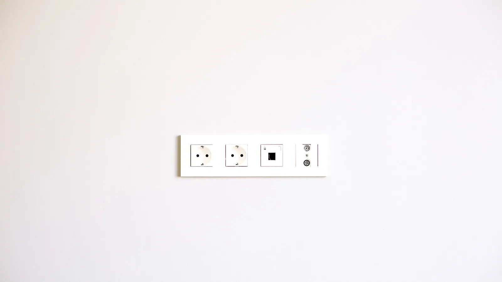 Australian wall socket outlet plate on a plain white wall, the AS/NZS 3112 interface any AU compliant power adapter has to plug into