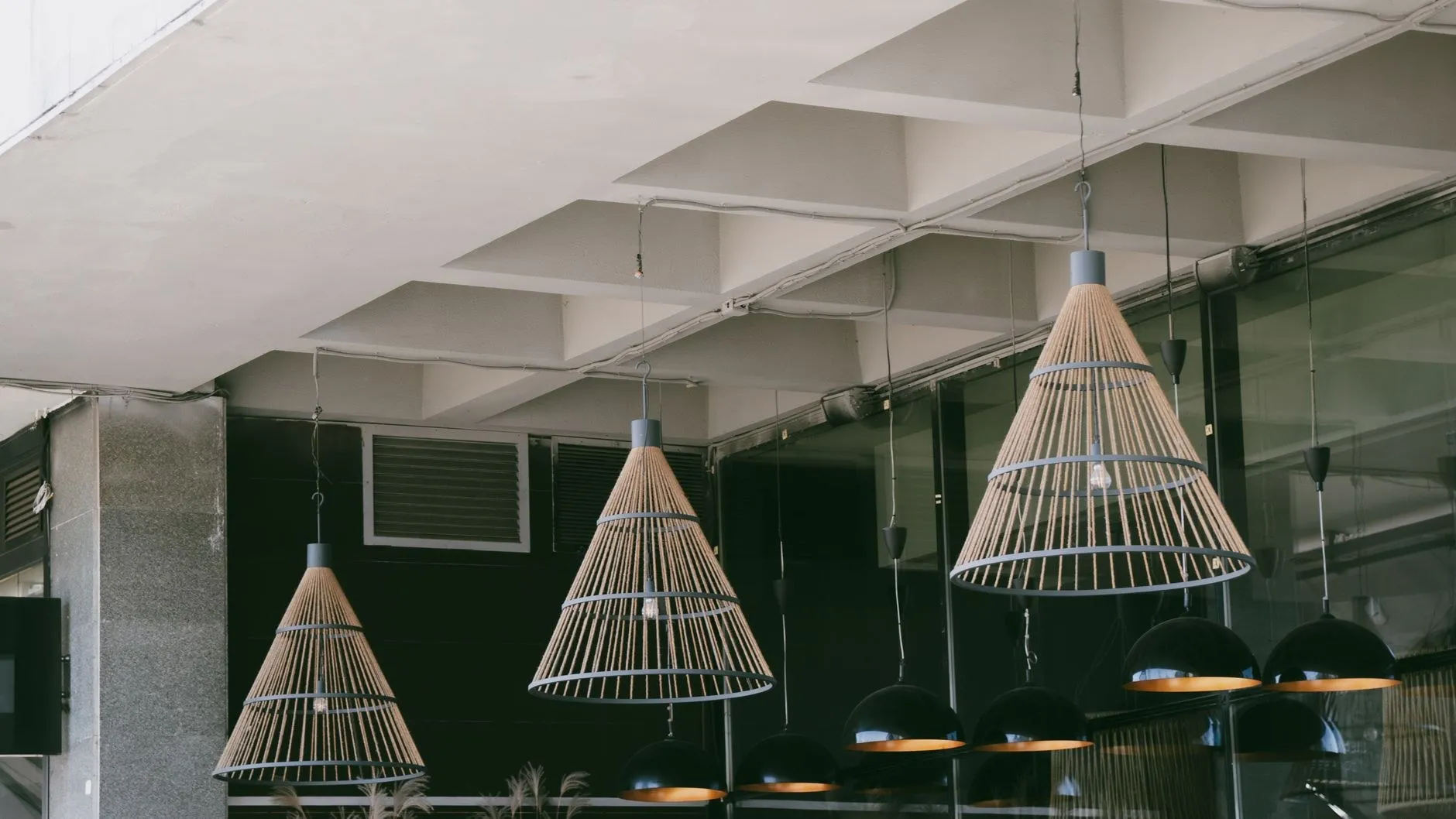 Woven shade pendant lights on a modern ceiling, an Australian hospitality lighting detail using SAA certified fixtures