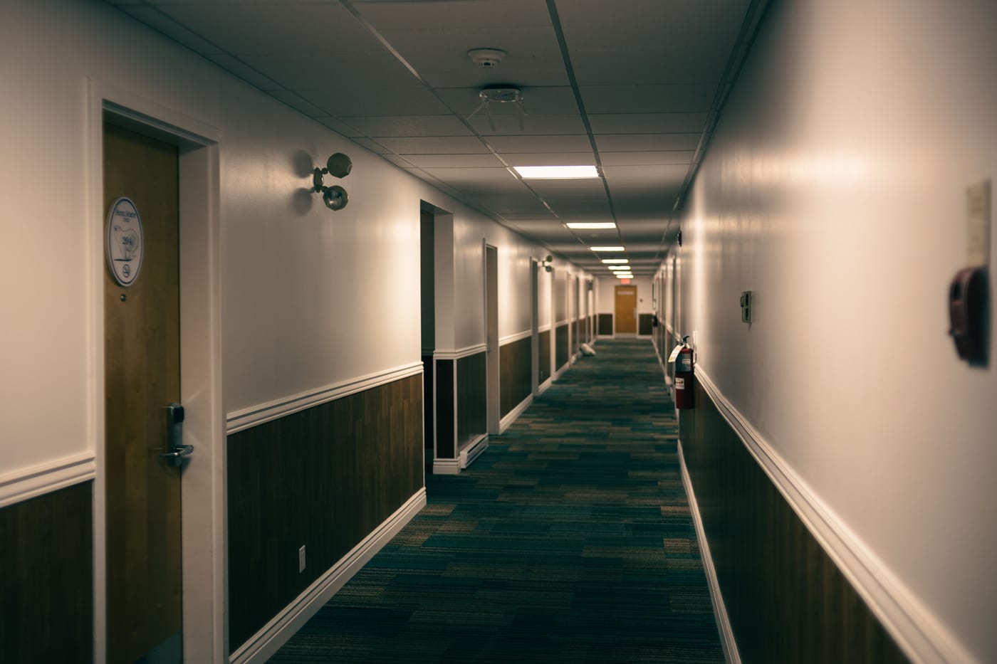 European hotel corridor lit by recessed ceiling luminaires — the kind of commercial interior where certification is checked before acceptance