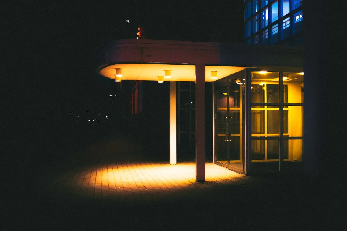 Delivered custom LED lighting project — a modern building entrance glowing with warm custom lighting at night, the finished result of an OEM/ODM LED lighting engagement