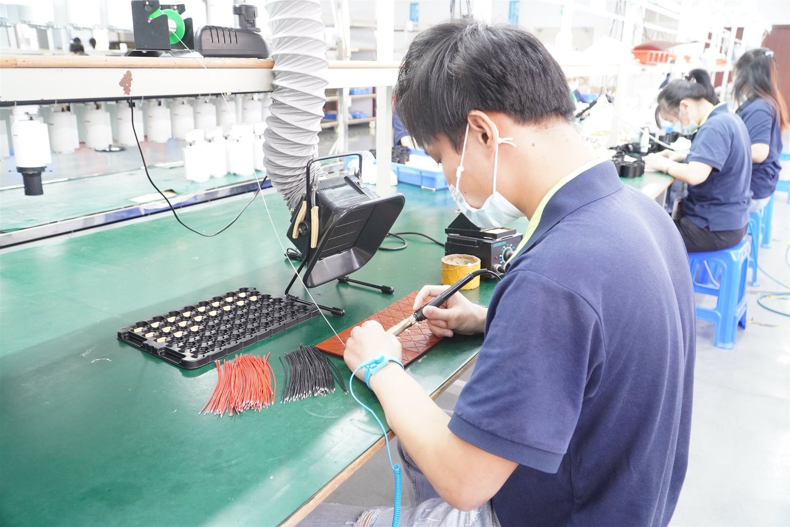 In-house production line with multiple assembly and testing workstations.