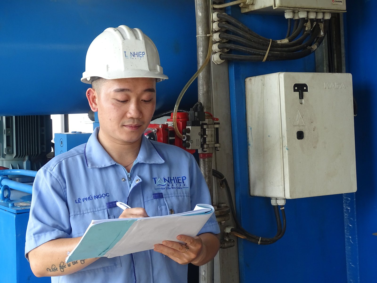 Factory staff member with a clipboard carrying out an on-site inspection walkthrough on a production floor