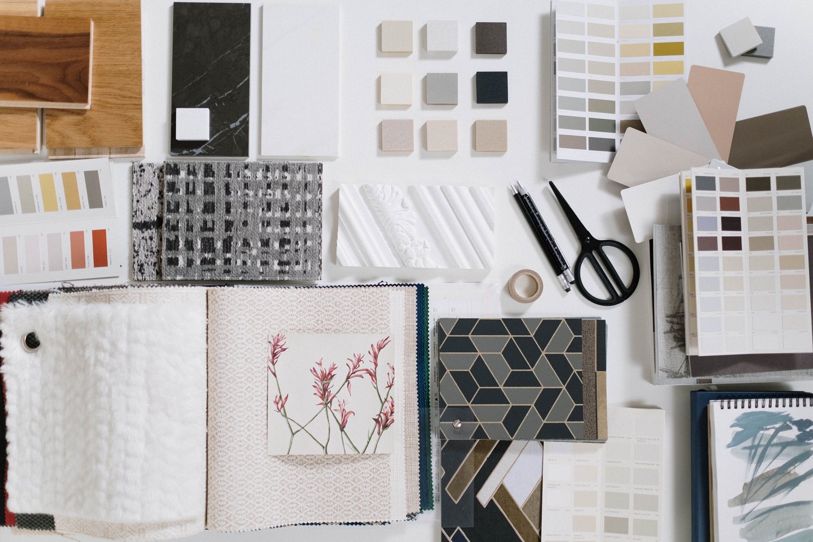 A flat lay of design and finish samples arranged on a workbench, representing the material decisions in a custom decorative lighting order