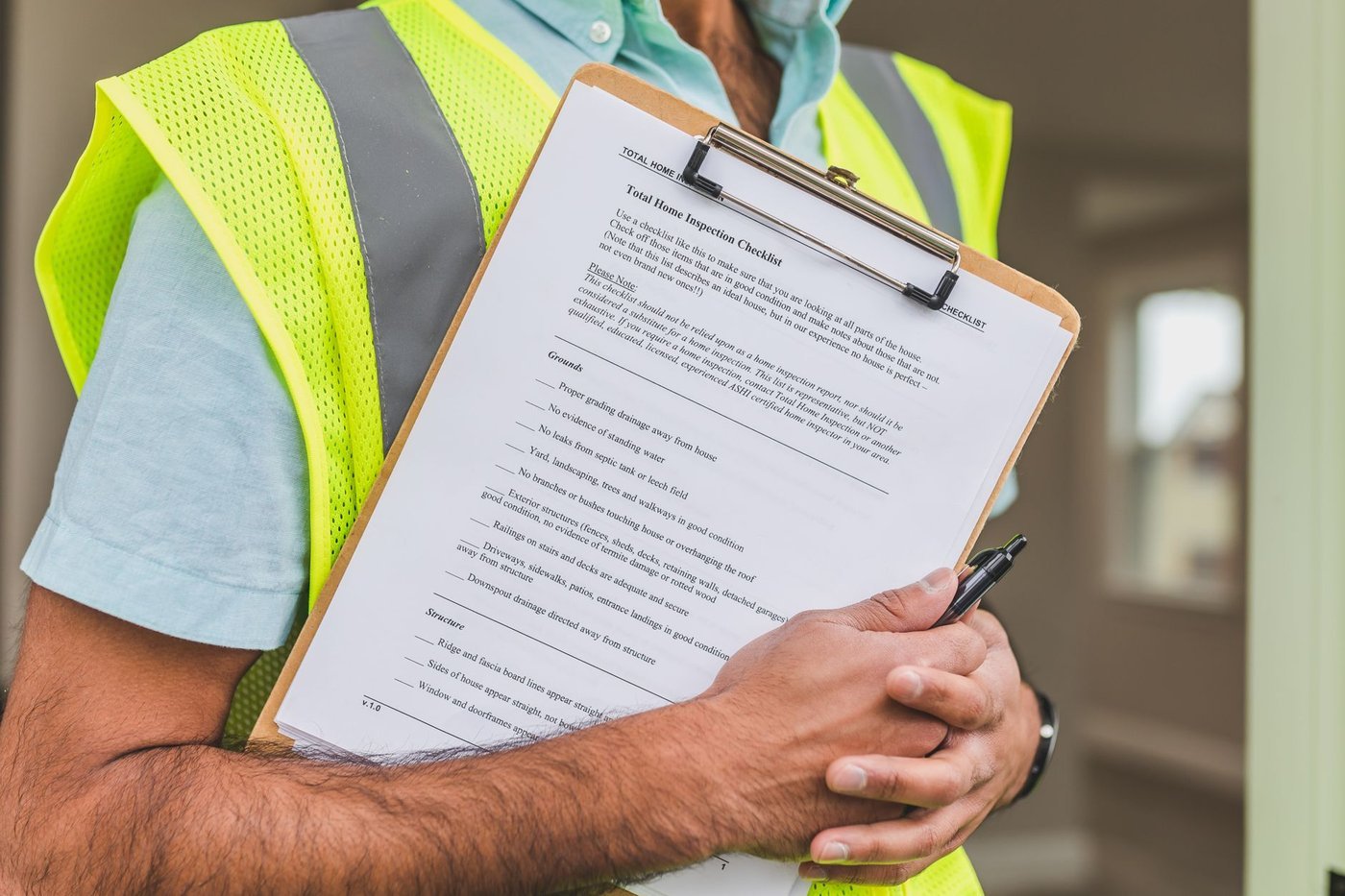 An inspector working through a written checklist with a clipboard inside a storage and production area