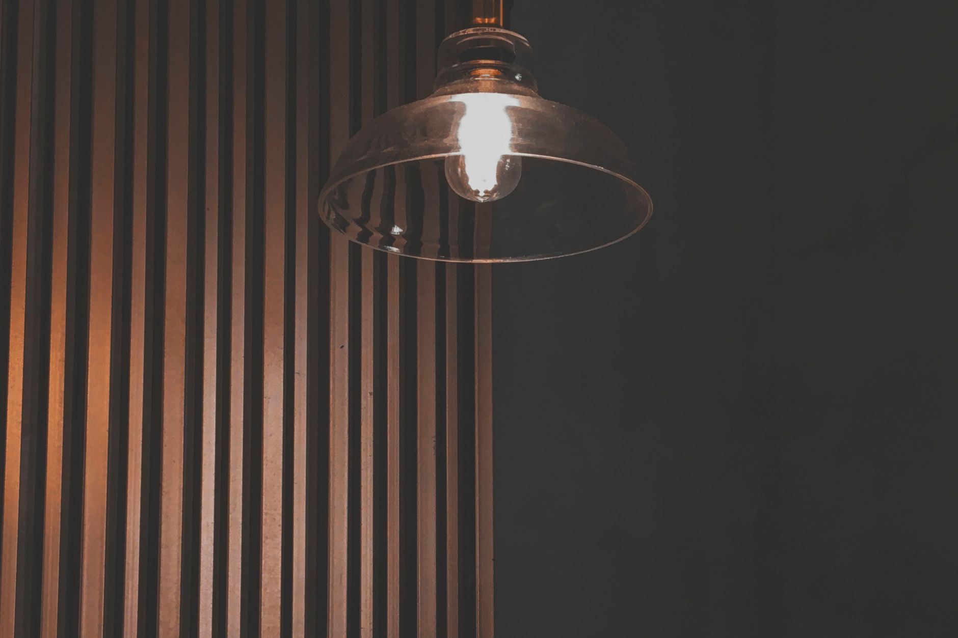 A warm, minimal interior lit by designer fixtures — the showroom and application spaces a private label lighting line serves